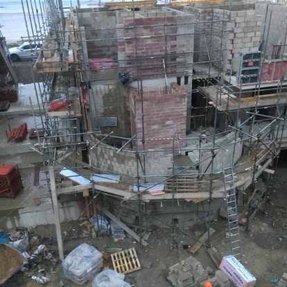 Curved scaffolding around stonework new build Jersey