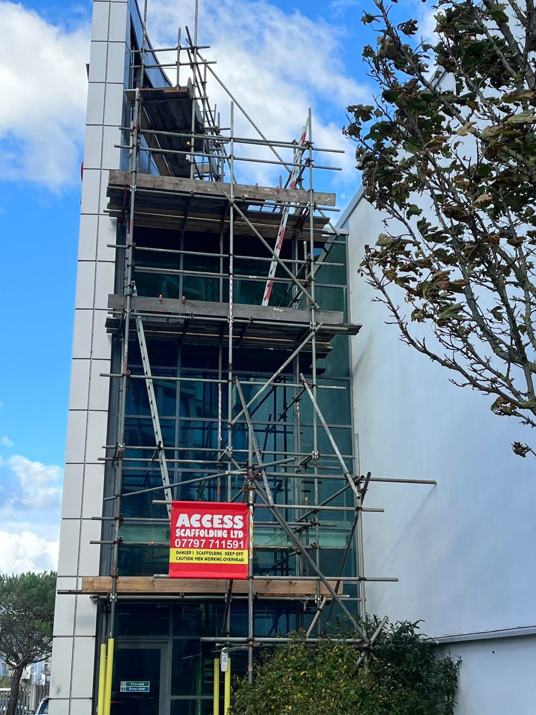 Access Scaffolding tower against a glazed stairwell on a commercial building in Jersey